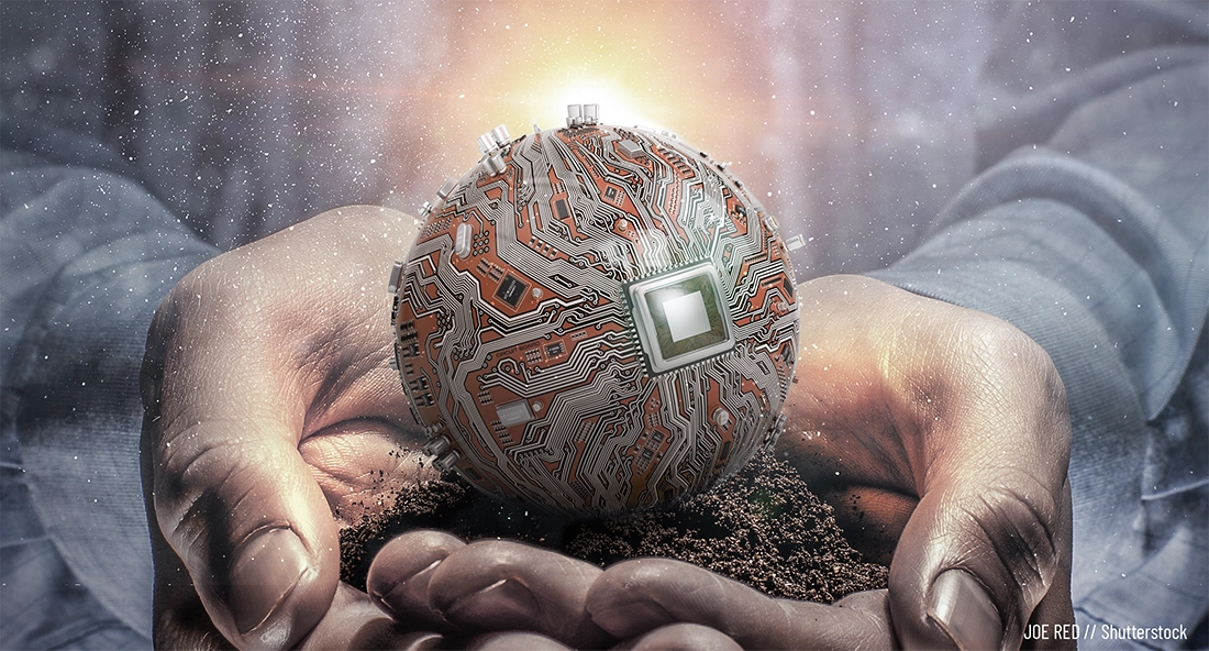 Close up of a man's cupped hands holding a small pile of rich dirt, atop which sits what looks like a spherical circuit board as though having recently sprouted from it